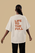 Person wearing a white t-shirt with 'LIFE TO THE FULL' text on the back against a beige background