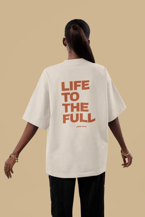 Person wearing a white t-shirt with 'LIFE TO THE FULL' text on the back against a beige background