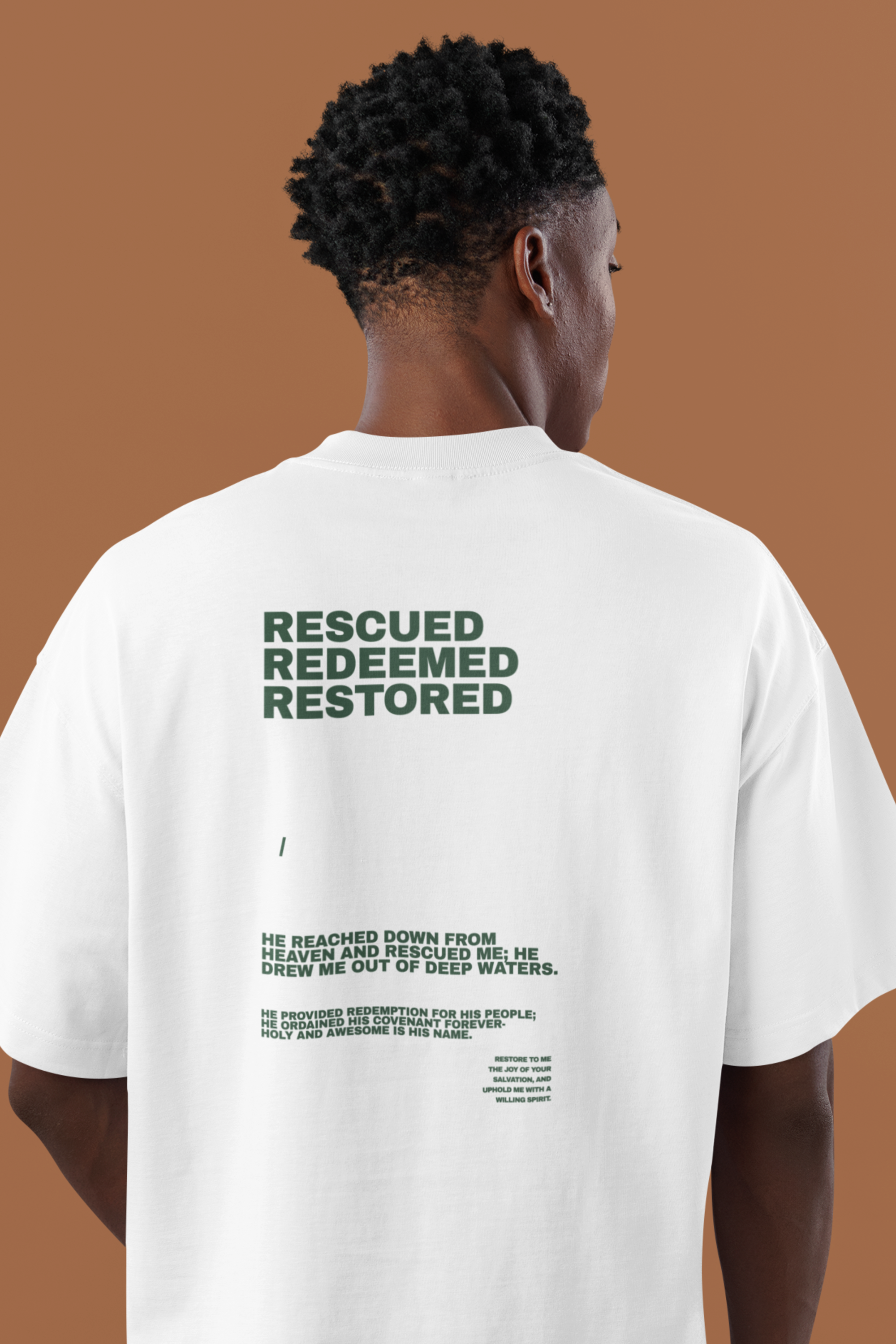 Christian man wearing a white t-shirt with bible verses on the back against a brown background