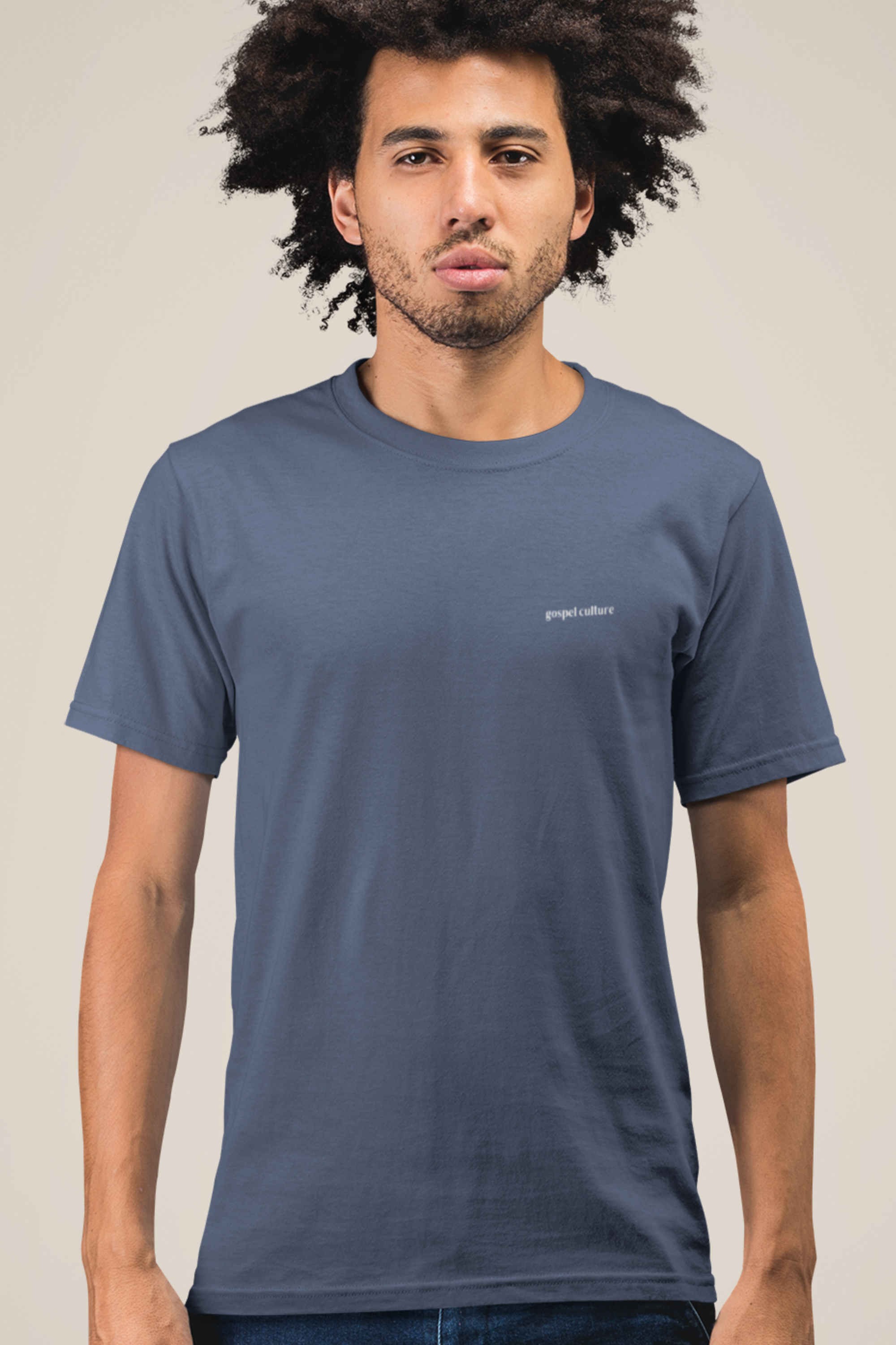 Man wearing a blue t-shirt with gospel culture logo on a beige background