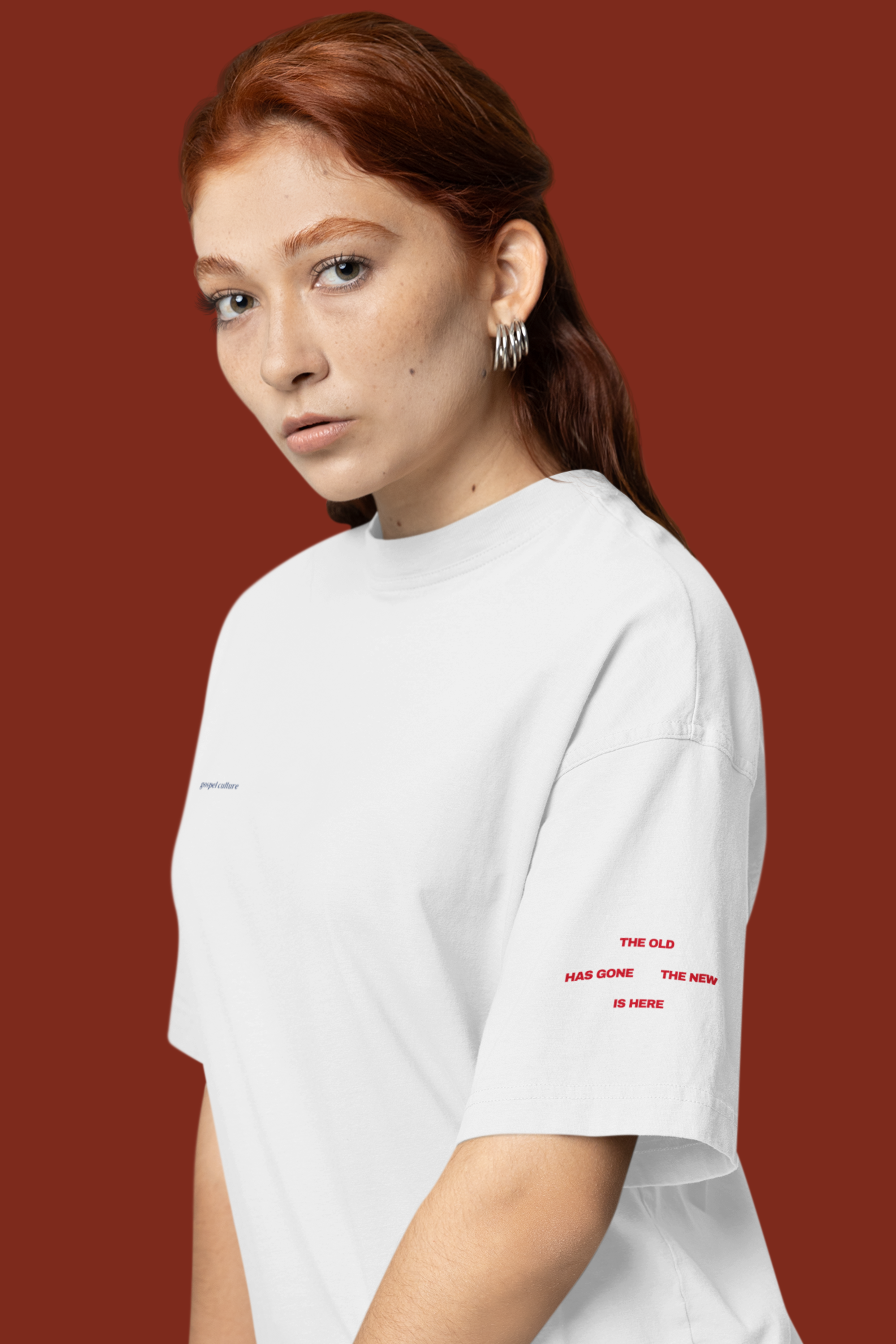 Person wearing a white t-shirt with red text on a brown background