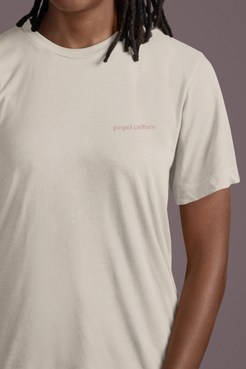 Lady  wearing a beige Christian t-shirt with 'gospel culture' text on a plain background